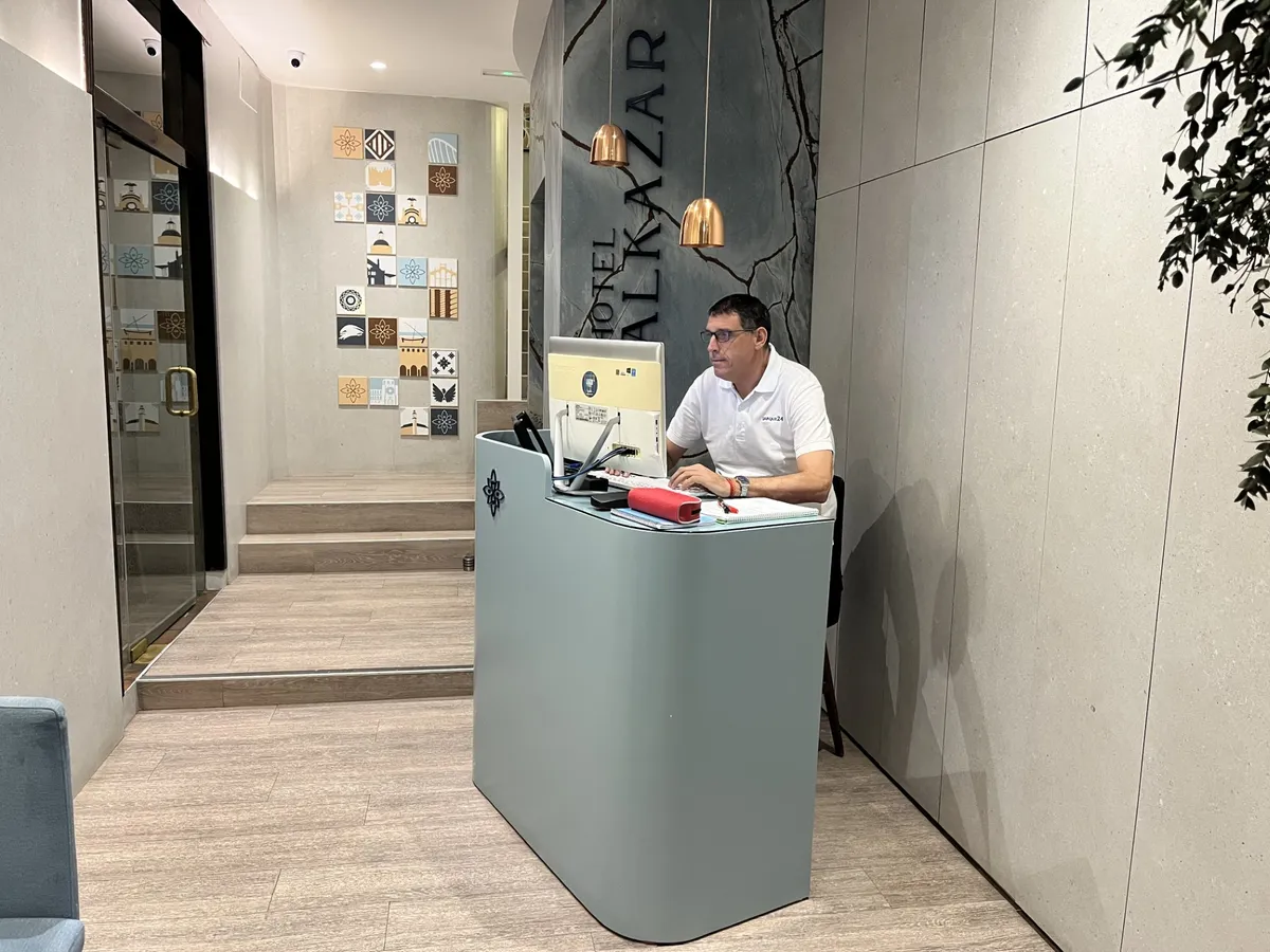 Recepcionista atendiendo en el mostrador de recepción